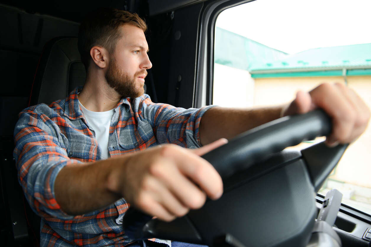 truck driver is distracted and seeing on his left window side 