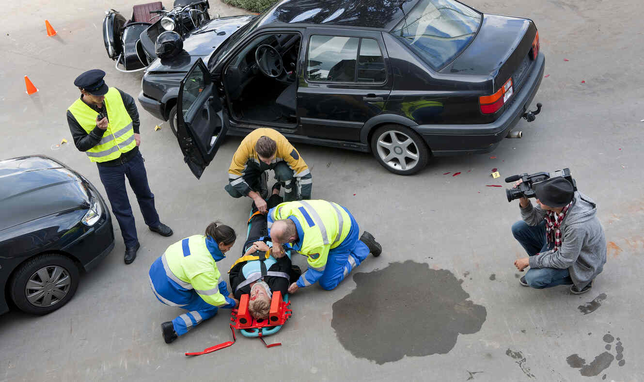 injured by car accident and laying on the road doctors are providing traetment 